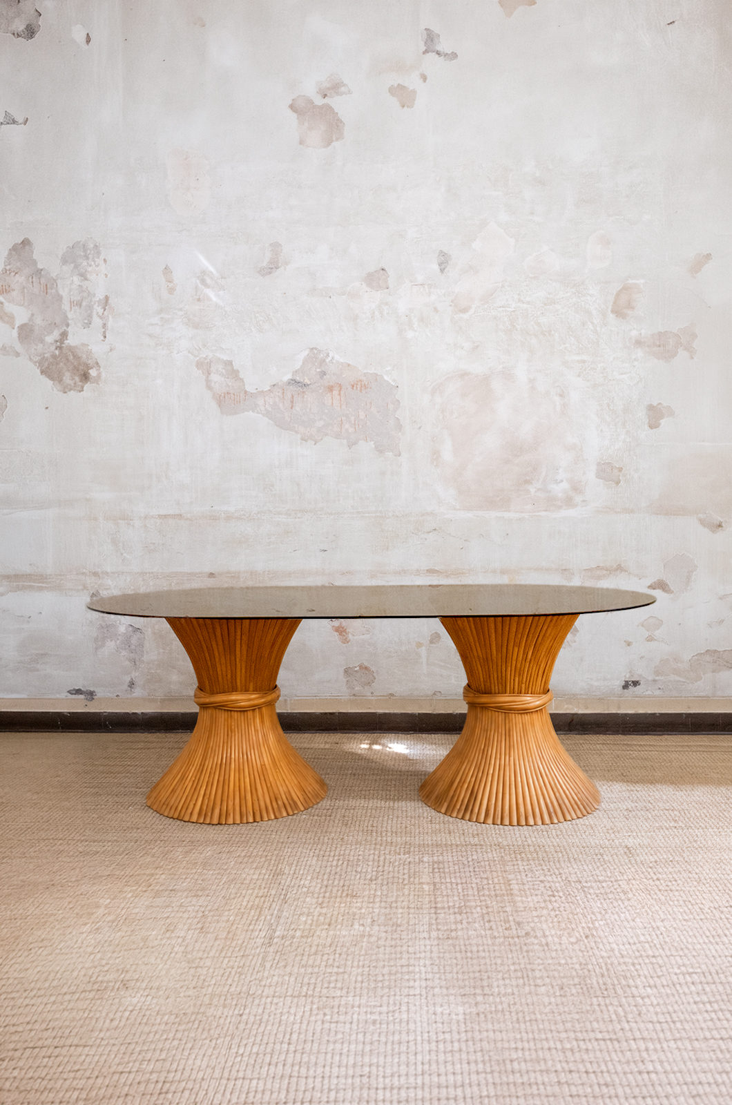 Tavolo da pranzo McGuire San Francisco anni ’70 con doppia base in rattan e piano ovale in vetro fumé